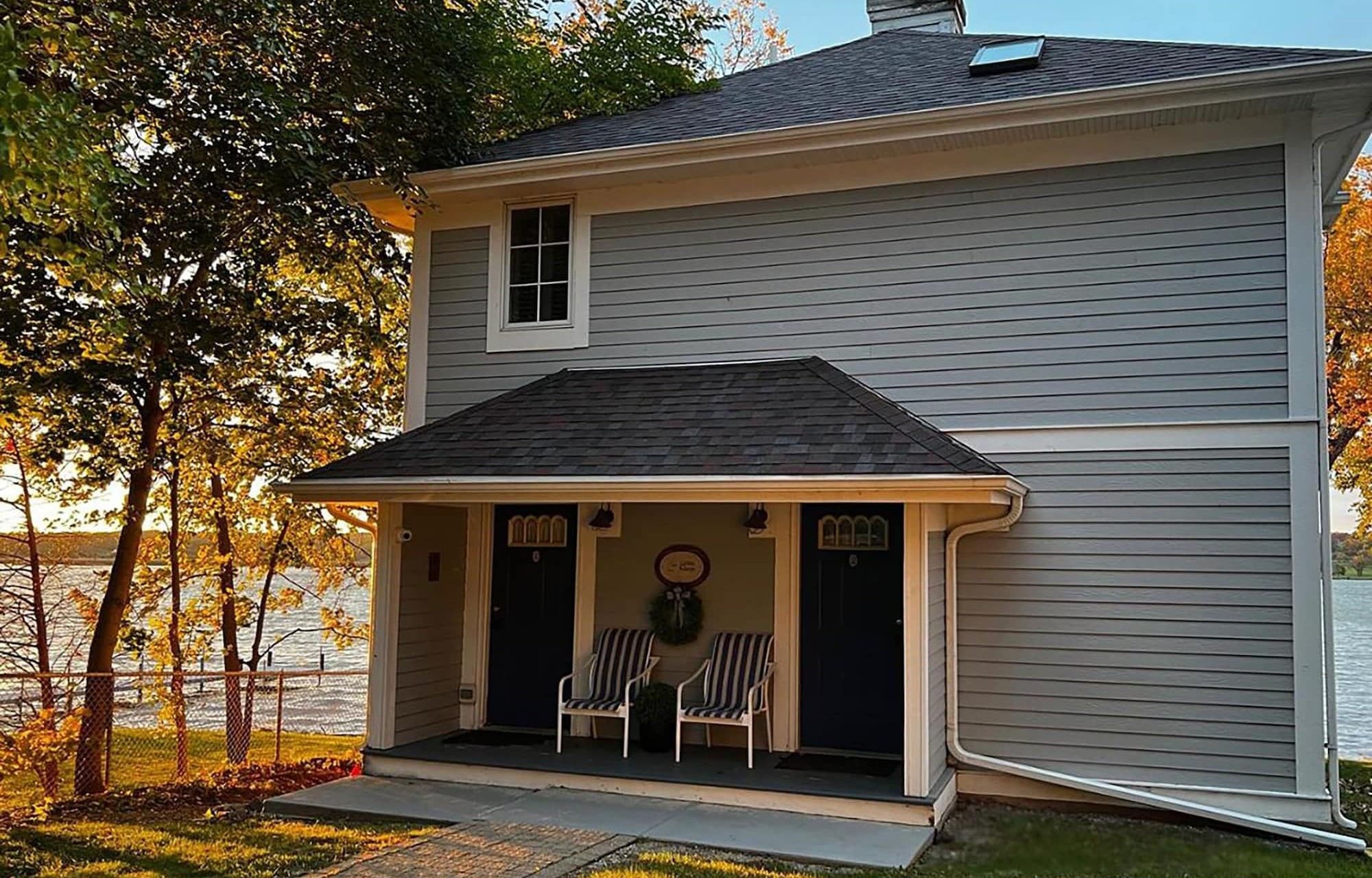 The Cottage entrance, with two striped chairs on its covered porch