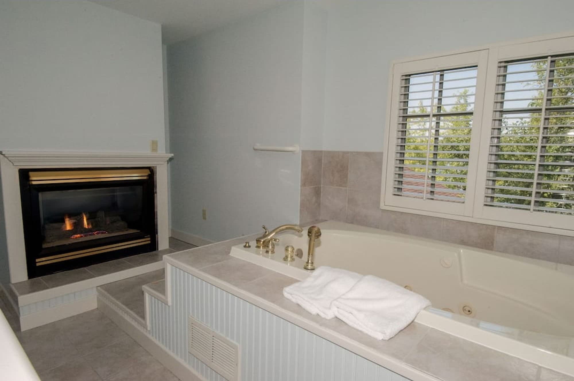 A two-person whirlpool beside a gas fireplace