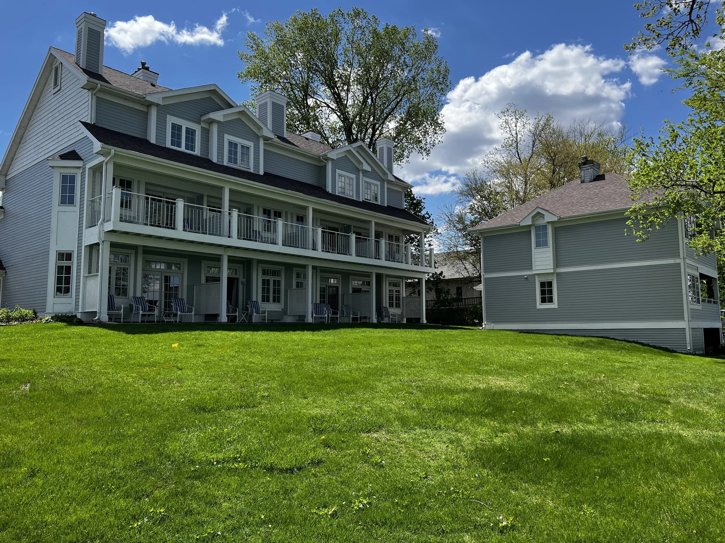 The Inn and the Cottage behind a wide green lawn under a blue sky