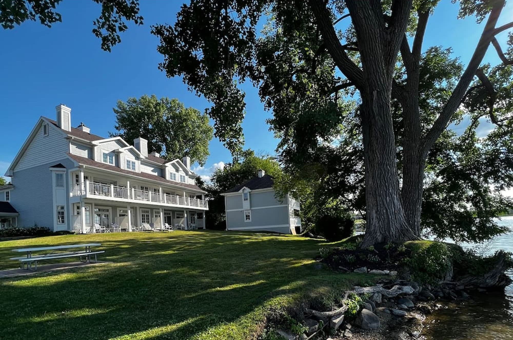 The Inn seen from the shore, framed by a large old tree